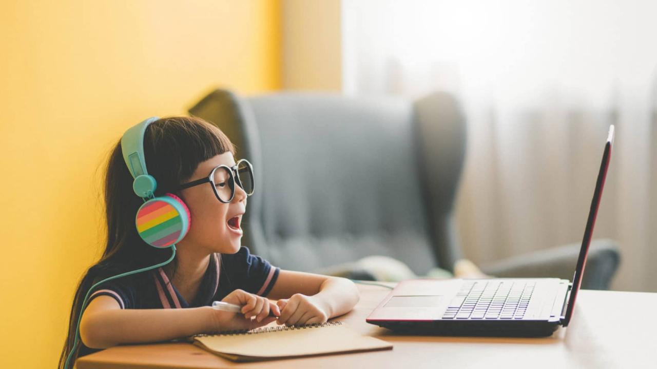 Young Asian Cute girl studying with laptop at home during pandemic