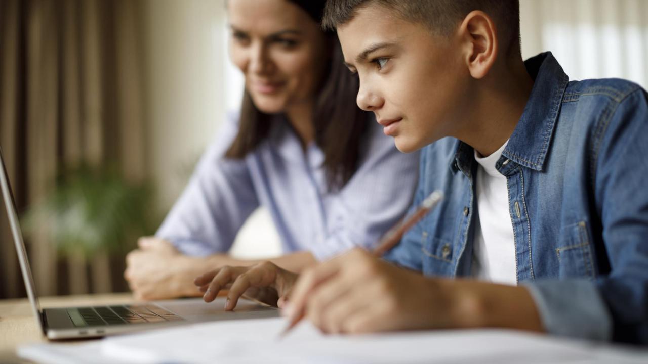 Mother helping teenager with homework