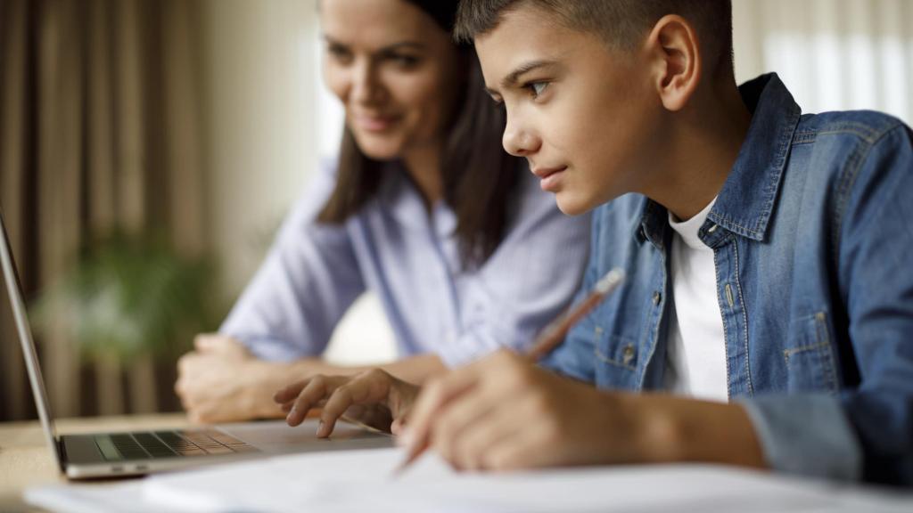 Mother helping teenager with homework