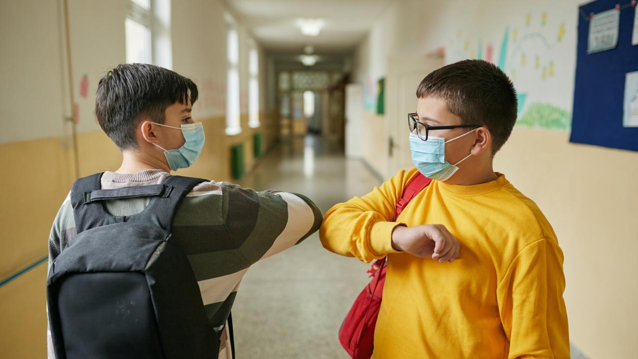 Responsible elementary student using a elbow bump as a alternative handshake during COVID-19 pandemic